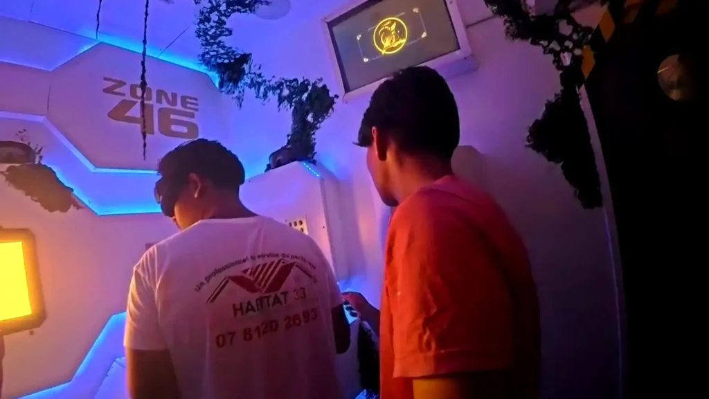 Deux participants en pleine immersion dans la Zone 46 de l'escape game The Hostel