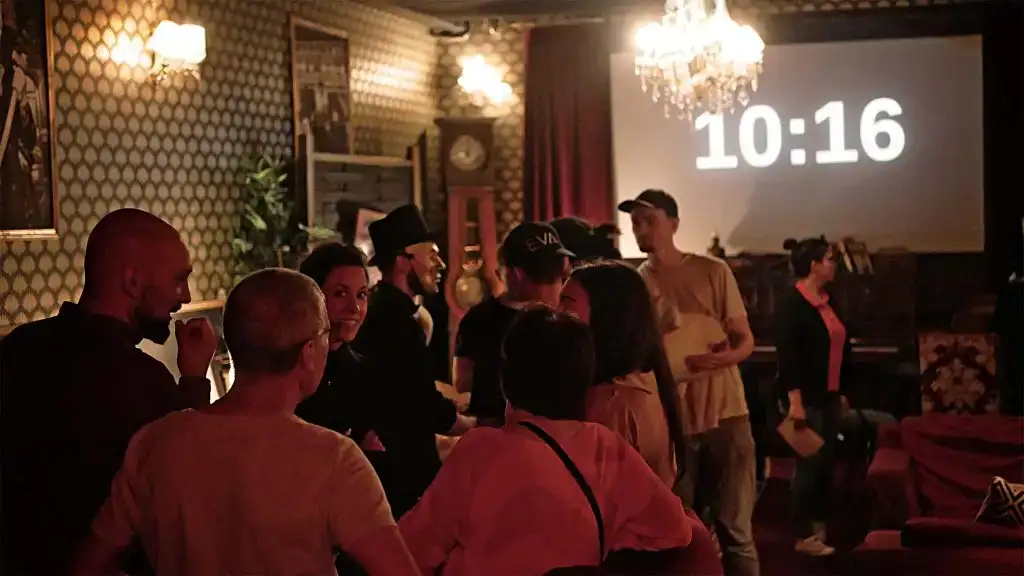 Groupe de participants lors d'une murder party en équipe, animée dans un salon vintage avec un chronomètre affichant 10:16, ambiance conviviale et immersive pour un team building original
