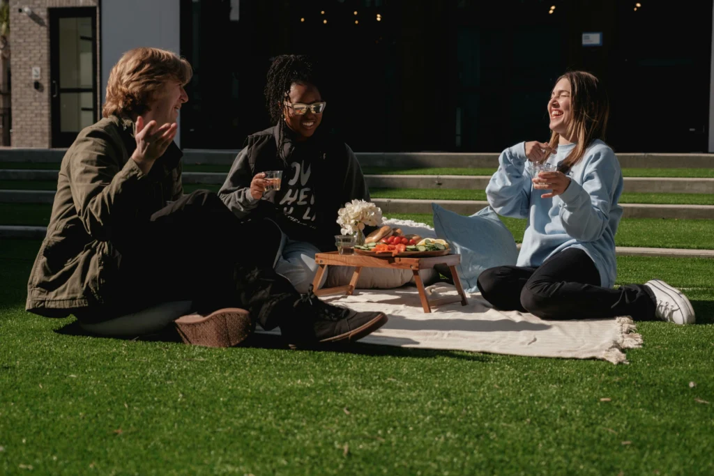 Trois personnes réunies pour un pique-nique sur l’herbe