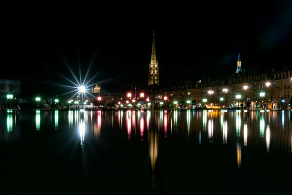 Façades illuminées de la place de la Bourse se reflétant dans le miroir d’eau à Bordeaux